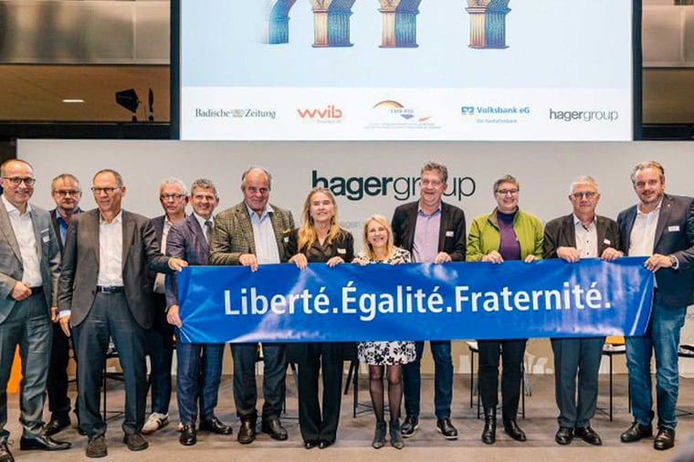 Eine Gruppe Menschen hält ein Plakat mit der Aufschrift "Liberté.Égalité.Fraternité."