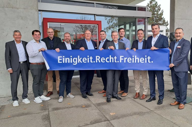 Eine Gruppe Menschen hält ein Plakat mit der Aufschrift "Einigkeit.Recht.Freiheit."